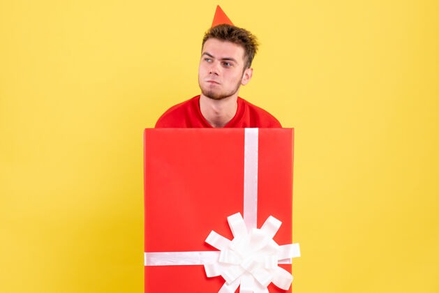 颜色正面图穿红衬衫的年轻男子坐在礼品盒内笔记本衬衫男