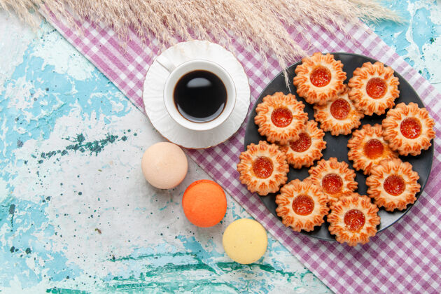 生的俯瞰美味的小饼干与法国马卡龙和咖啡的蓝色办公桌饼干饼干甜甜的糖色茶法国麦卡龙饼干