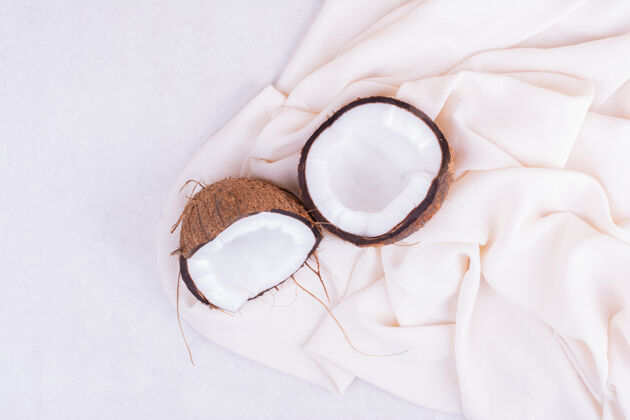 品质在白色桌布上把多毛的椰子掰成两半扁豆甜味异国情调