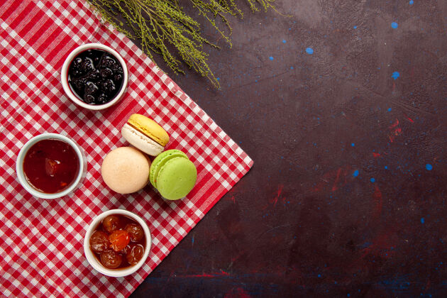 游戏俯瞰美味的法国马卡龙果酱深色背景果酱甜茶蛋糕饼干甜球场顶部果酱