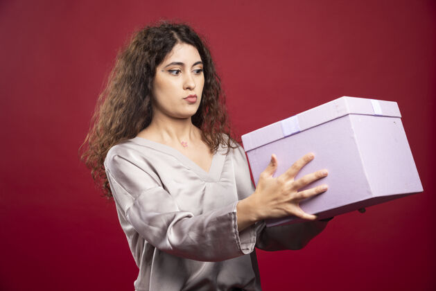 女人年轻女子看着紫色的礼盒微笑礼物快乐
