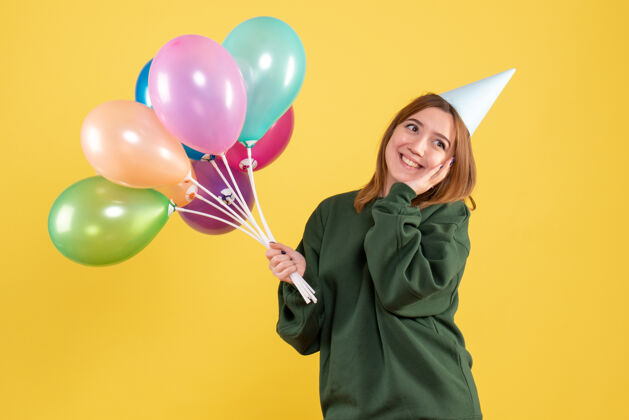 女性正面图：带着彩色气球的年轻女性欢乐生日年轻
