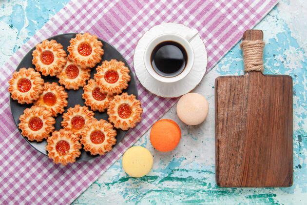 视图俯瞰美味的小饼干与法国马卡龙和咖啡蓝色背景饼干饼干甜甜的糖色茶小麦卡龙顶部