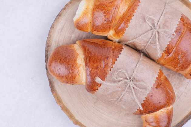 奶油两个羊角面包包在木板上面包房熟的拼盘