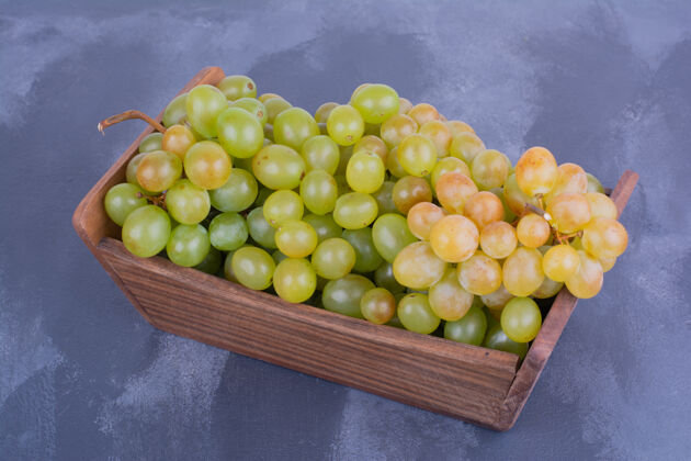 美味一堆绿色的葡萄放在一个木制托盘里素食热带乡村