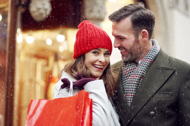 零售一对夫妇在冬季购物时花钱微笑优雅编织帽子