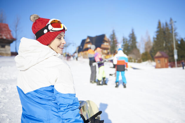 山滑雪板女孩走在斜坡上穿人群滑雪