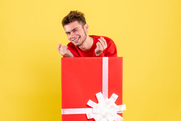 礼物正面图年轻男性站在礼品盒内雪站着男性