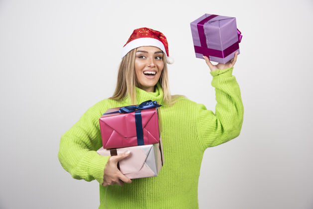 快乐年轻女子手里拿着很多圣诞礼物女士礼物盒子