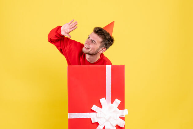 纸正面图：礼品盒内穿红色衬衫的年轻男性红色内部圣诞节