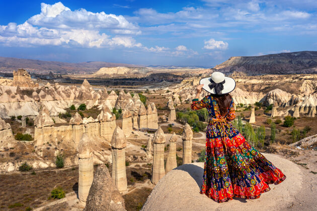 自然土耳其卡帕多西亚 一个穿着波西米亚服饰的女人站在爱谷上帽子冒险旅行者