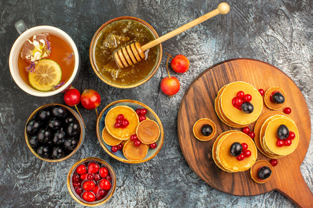 碗用蜂蜜和水果在砧板上特写经典煎饼画笔蜂蜜容器