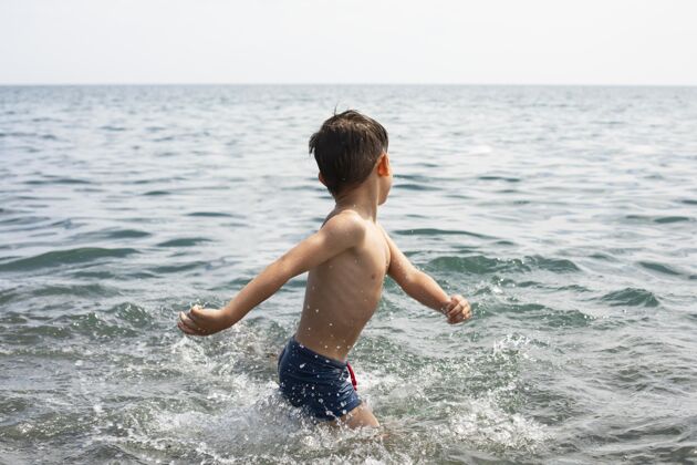 海滩中枪小子在水里玩孩子乐趣生活方式