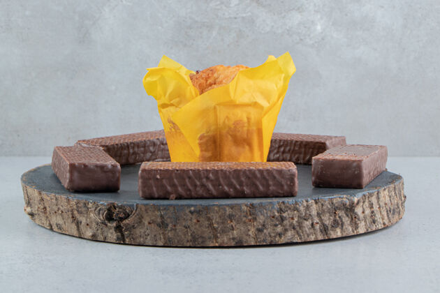 巧克力巧克力薄饼围绕在大理石背景板上的纸杯蛋糕上美味美味烘焙食品