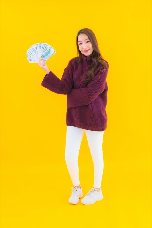 粉丝一幅美丽的亚洲年轻女子的画像 带着大量的现金和金钱账单钞票信用