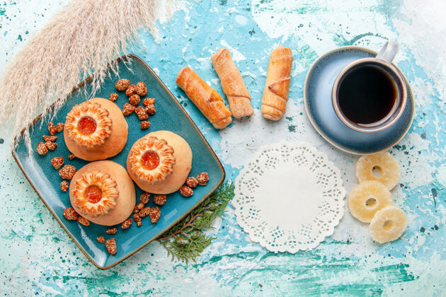 戒指俯瞰美味的饼干与干菠萝环百吉饼和咖啡上的蓝色背景饼干甜甜的糖的颜色风景盘子早餐