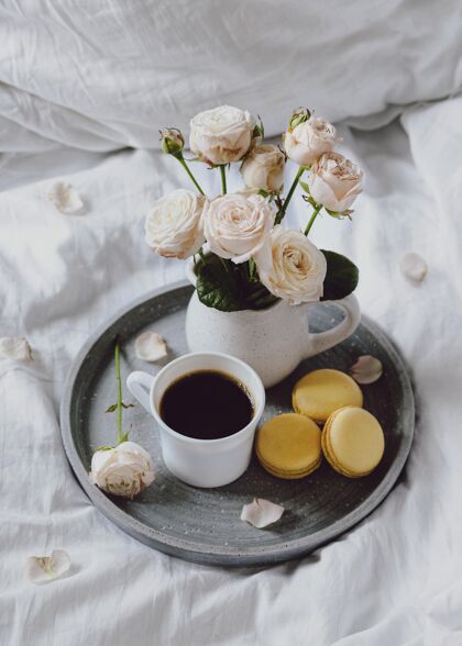 咖啡早餐碗里有咖啡和麦卡龙小吃床鲜花