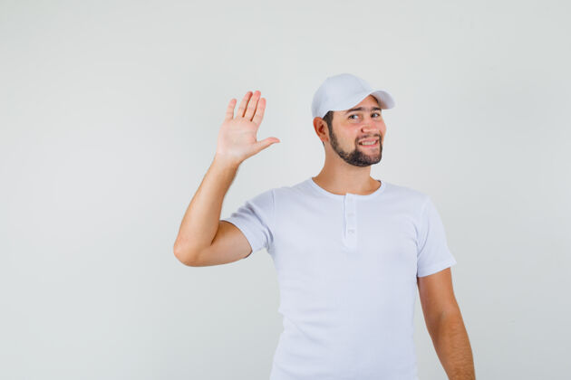 脸年轻人挥手致意 身穿白色t恤 戴着帽子 看上去很清新 正面照男性男人工作室