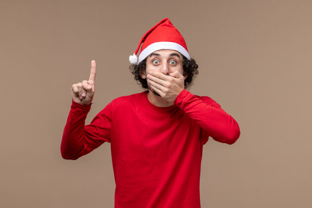 肖像正面图红色的男性在棕色背景上震惊的表情节日情感圣诞节喜剧演员微笑棕色