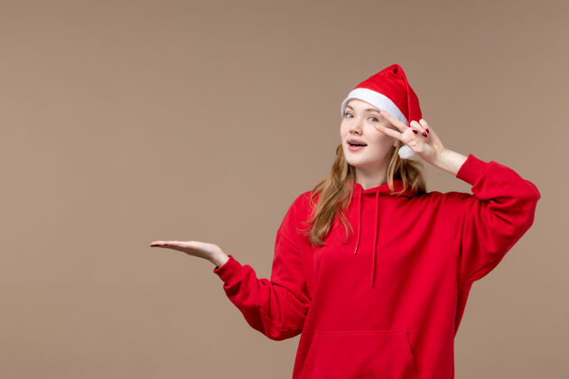 人前视图圣诞女孩摆出棕色背景节日新年圣诞制服圣诞女孩圣诞节
