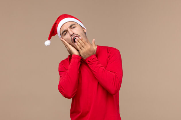 肖像前视图年轻男性打哈欠 试图在圣诞节假期睡觉睡眠电话圣诞节