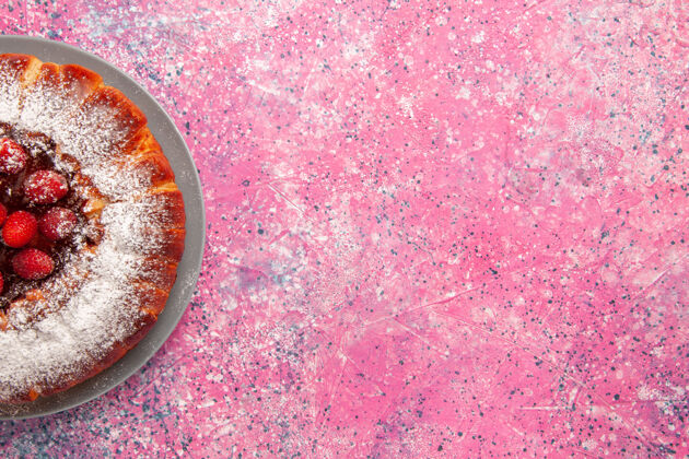 手镯顶部近距离观看美味的草莓蛋糕 在浅粉色墙壁上用糖粉烤蛋糕 烤甜甜饼干 饼干 派烘焙派饼干