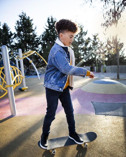 公园侧视图男孩在公园玩滑板垂直孩子童年