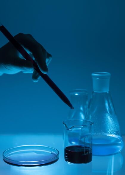 化学近距离手持吸管在低光组成实验室玻璃器皿