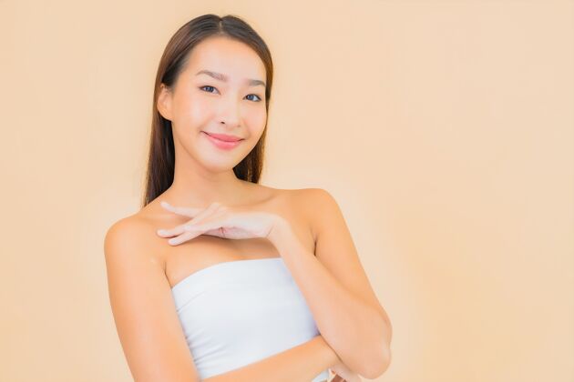 身体肖像美丽的年轻亚洲女子在温泉与自然化妆米色衰老皮肤护理干净