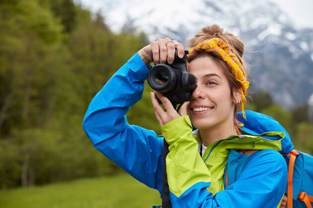 头带旅游 爱好和冒险的概念积极的年轻游客在专业相机上拍摄风景山远足山