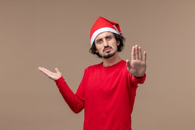 帽子前视图年轻人要求停止对棕色背景节日情感圣诞节肖像成人帽子
