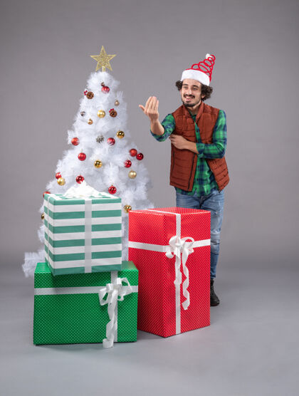 表演者年轻的男性在灰色的节日礼物帽子圣诞帽喜剧演员