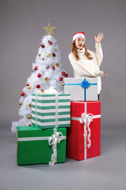 圣诞树年轻的女性在灰色的礼物帽子购物女性