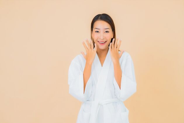 诊所肖像美丽的亚洲年轻女子穿着米色的微笑浴袍看成人自然
