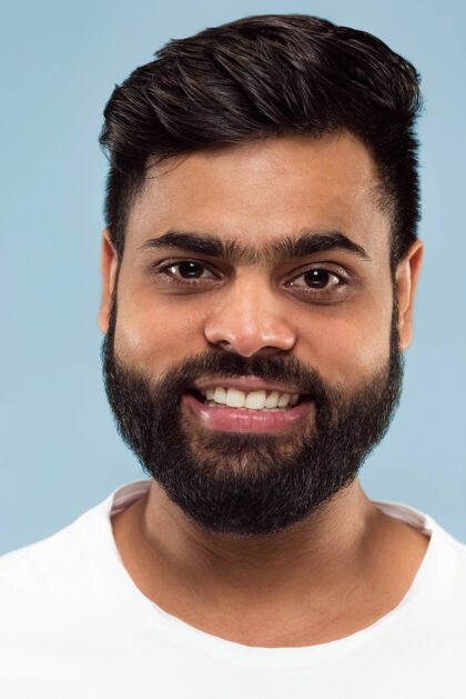 选择穿着白衬衫留着胡子的印度年轻人的特写肖像站着微笑成人手势人