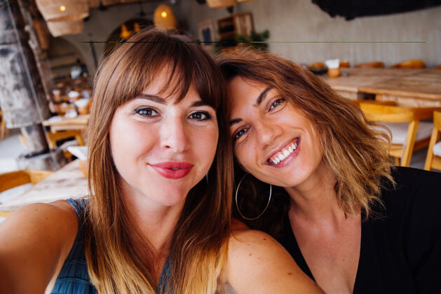 朋友两位自然妆容 短发的欧洲白人女性朋友在夏日咖啡馆自拍快乐咖啡馆年轻