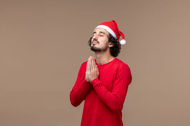 时尚前视图年轻人祈祷棕色背景圣诞假期棕色快乐前面