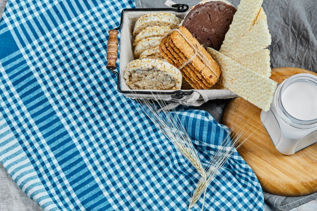 大理石一篮饼干和一罐牛奶放在一张铺着桌布的大理石桌子上甜点燕麦片巧克力