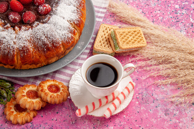 早餐正面图美味的草莓蛋糕糖粉加上一杯茶华夫饼和饼干浅粉色表面蛋糕甜饼干饼干茶草莓甜点蛋糕