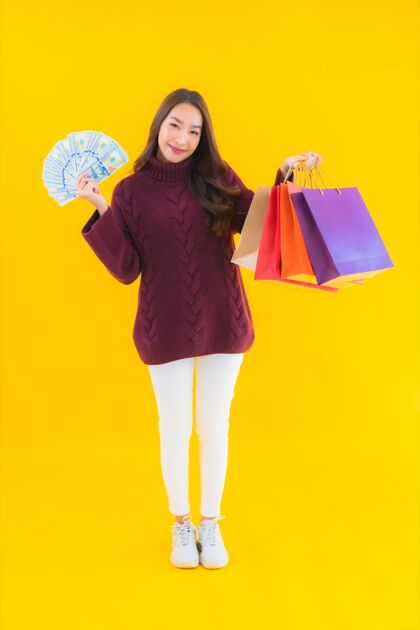 魅力用五颜六色的购物袋描绘美丽的亚洲年轻女子手机购物狂付款