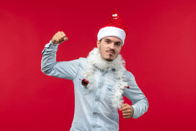 帽子红墙上年轻人愤怒表情的正面图快乐圣诞节快乐