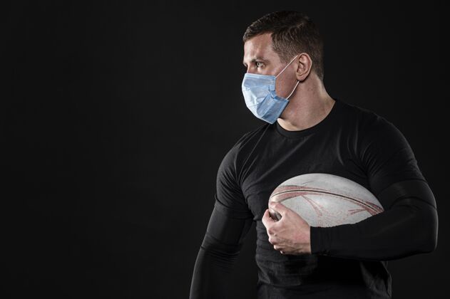 比赛男橄榄球运动员带着医用面罩和复制空间接触医疗面具运动员