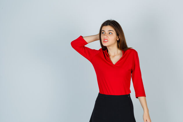 表情穿着红衬衫的年轻女士 手拉着裙子放在脑后 看上去很体贴思考成人独自