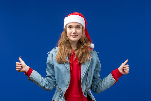 微笑正面图：年轻女性在蓝色背景上微笑圣诞情绪色彩肖像人快乐