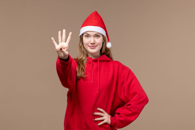 圣诞节前视图年轻女性显示在棕色背景上的数字情感圣诞假期帽子节日成人
