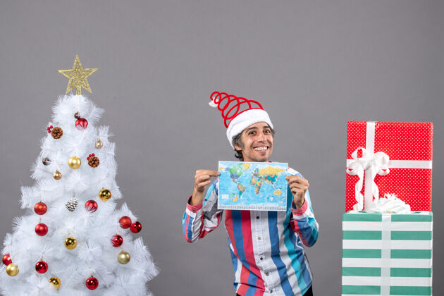 圣诞老人正面图微笑的男子戴着螺旋弹簧圣诞帽双手拿着地图人假期男人