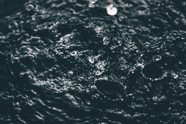 雨高角度特写镜头的飞溅的水在水面上的湖泊自然饮料滴水