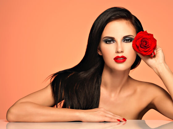 发型美丽的女人的肖像 明亮的时尚妆容 捧着红玫瑰黑发黑色花