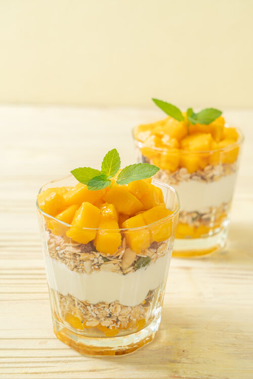 燕麦新鲜芒果酸奶和格兰诺拉麦片在玻璃-健康的食物风格脆皮菠萝酸奶