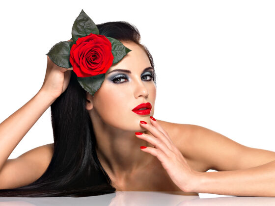 魅力脸上的美女用鲜艳的时尚妆容和红花隔离头发化妆品直